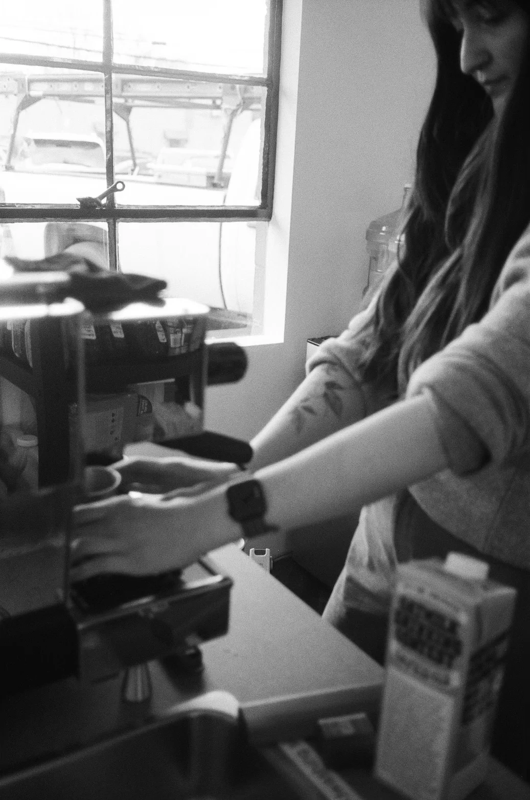 Aja preparing espresso in the original small space, in black and white