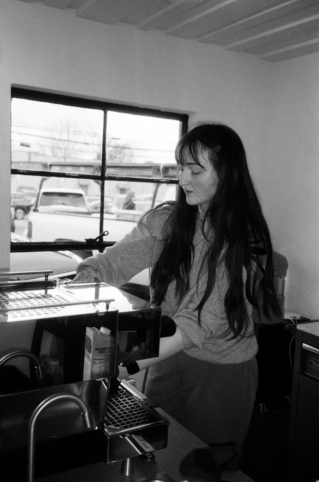 Aja behind the espresso machine in the original space, in black and white