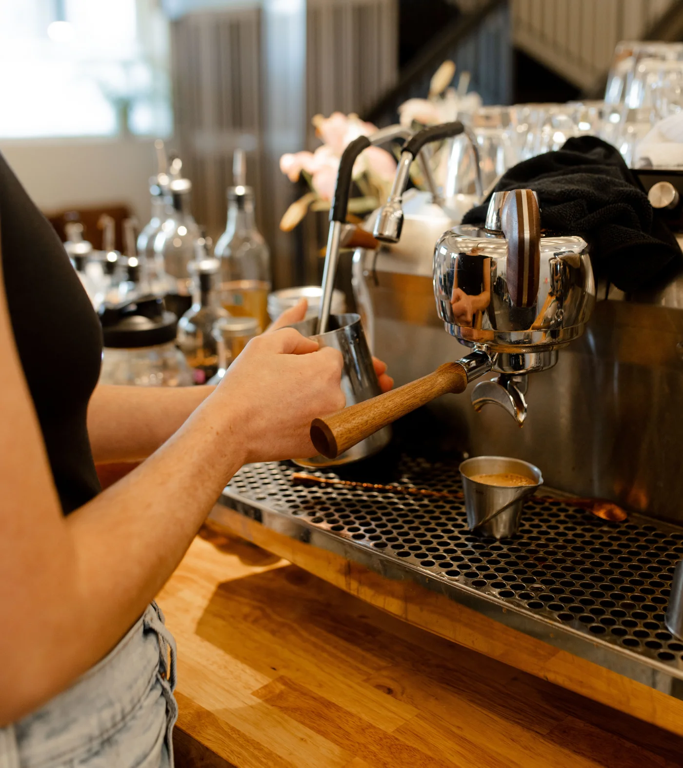 Milk being steamed while espresso pours behind the Give & Take bar
